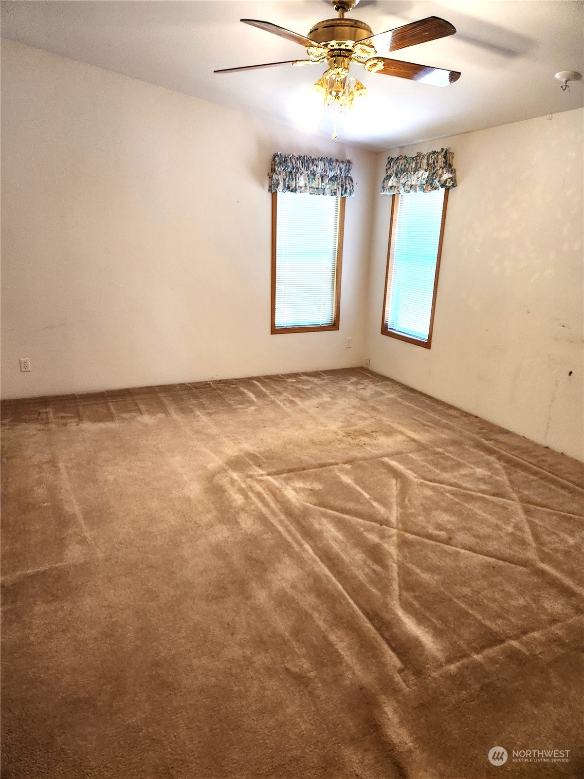 705 Eufaula Heights Road Longview, WA 98632 - Photo 7 of 17 an empty room with windows and chandelier fan