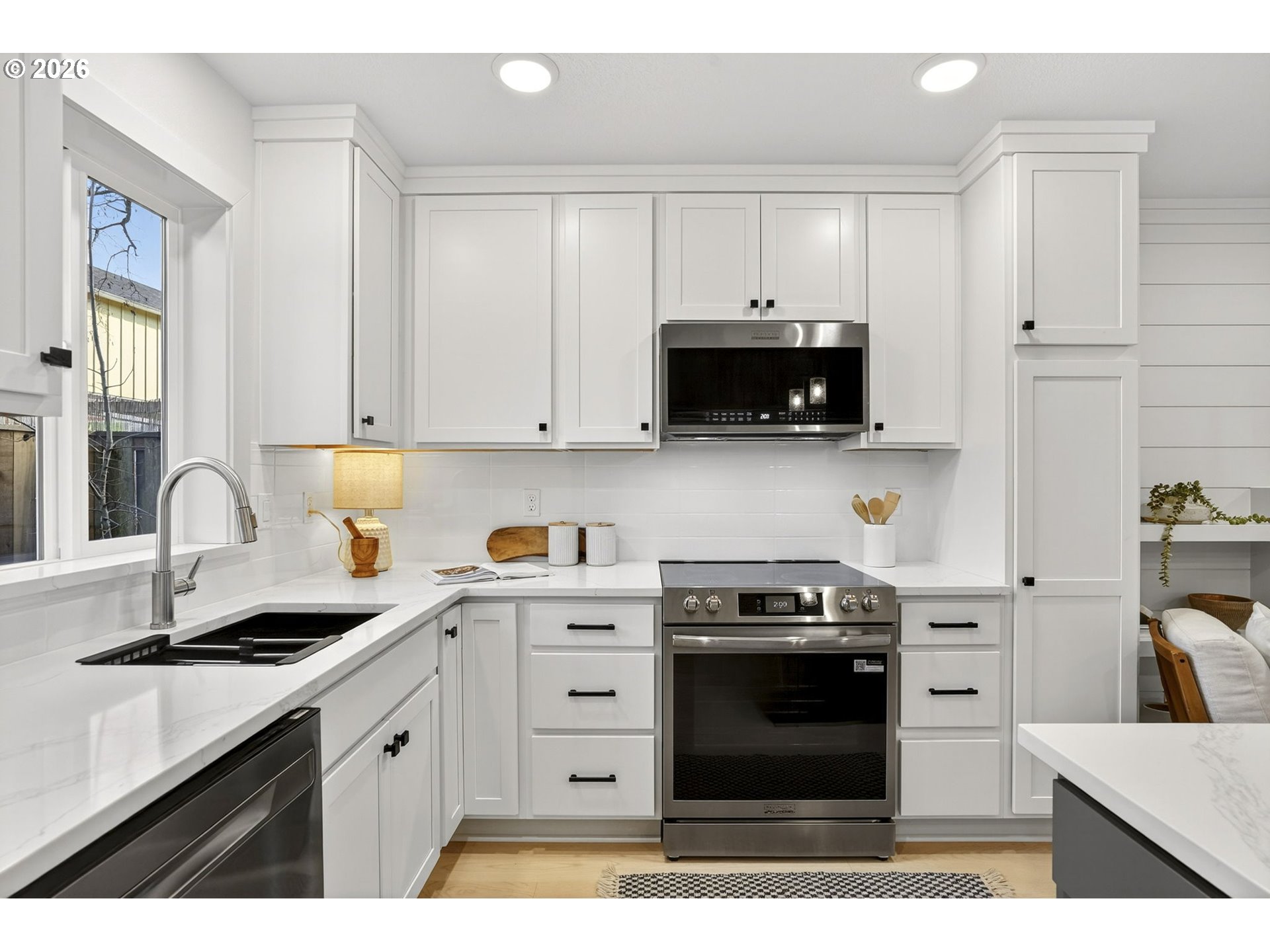 7602 Southeast Carlton Street, Unit B Portland, OR 97206 - Photo 10 of 34 a kitchen with stainless steel appliances granite countertop a stove a sink and a microwave