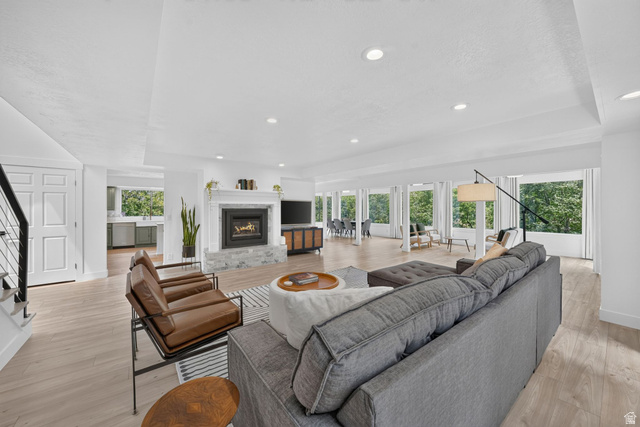 1979 Cave Hollow Way Bountiful, UT 84010 - Photo 8 of 59 Spacious living area featuring light wood-finish flooring, recessed lighting, and a modern fireplace with a white mantel and stone surround