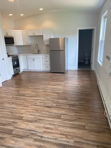 a view of kitchen and hall with wooden floor