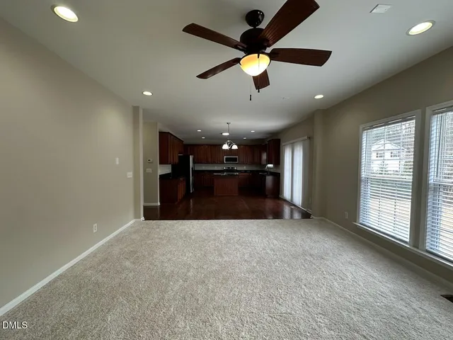 an empty room with a ceiling fan and window