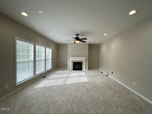 a view of an empty room with a fireplace and a window