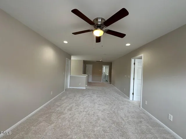 en empty room with windows and ceiling fan