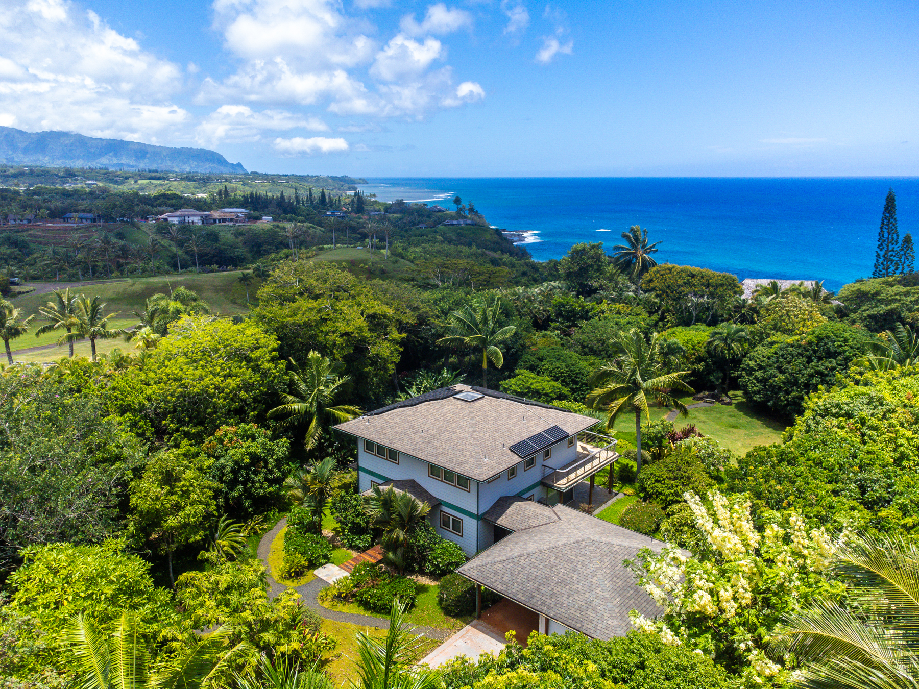 an aerial view of a house with a garden and lake view