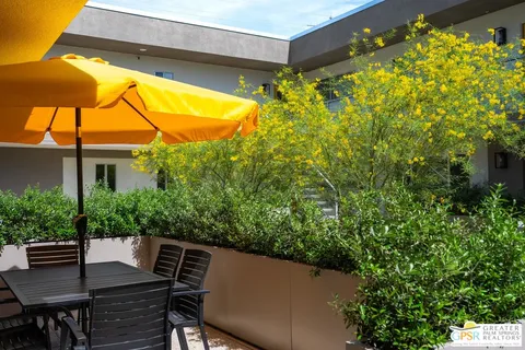 a view of a patio with table and chairs under an umbrella