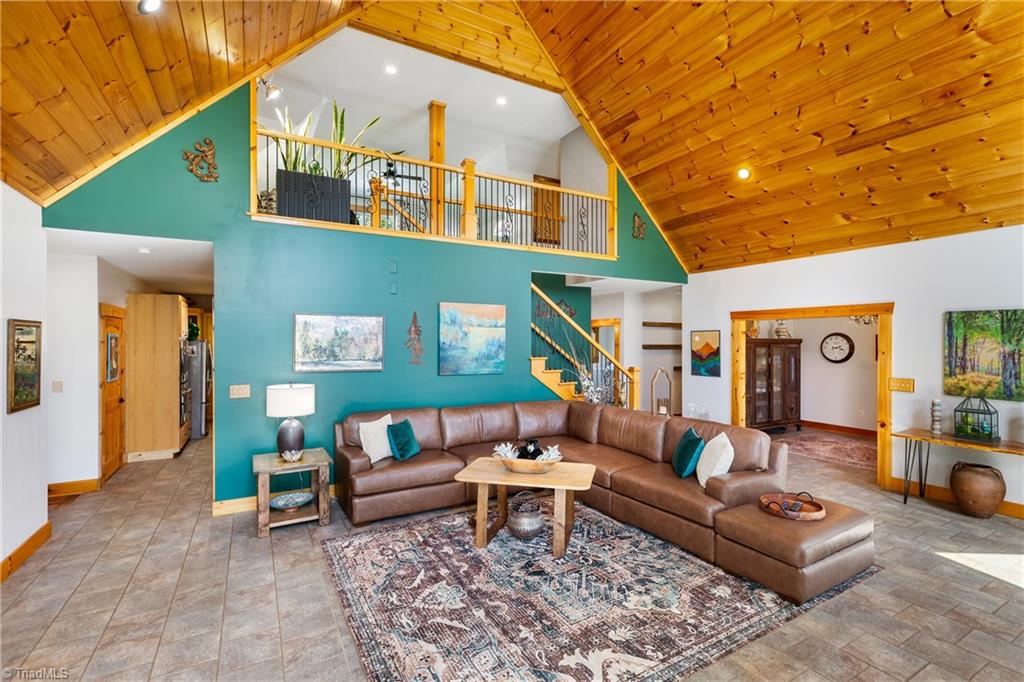 246 Bear Trail Lowgap, NC 27024 - Photo 10 of 50 Living room with staircase leading to upper level. Foyer is to the right. Kitchen is behind the living room area.