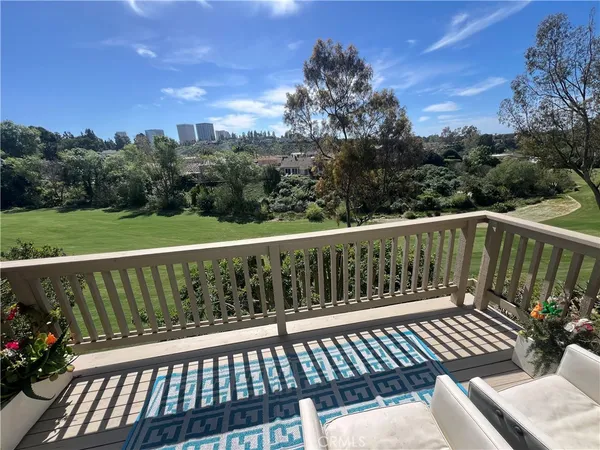 a balcony with wooden floor and trees in the background