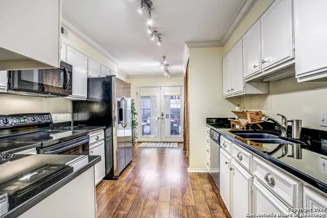 a kitchen with stainless steel appliances a stove a sink and a refrigerator