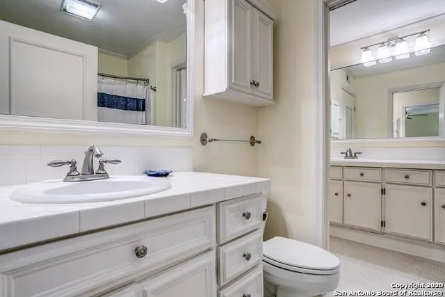 a bathroom with a sink a toilet and a mirror