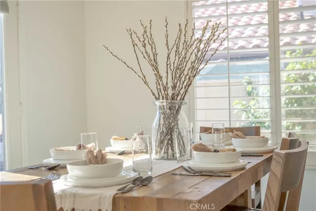 a dining room with furniture and a large window