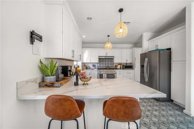 a kitchen with stainless steel appliances a table chairs and a refrigerator