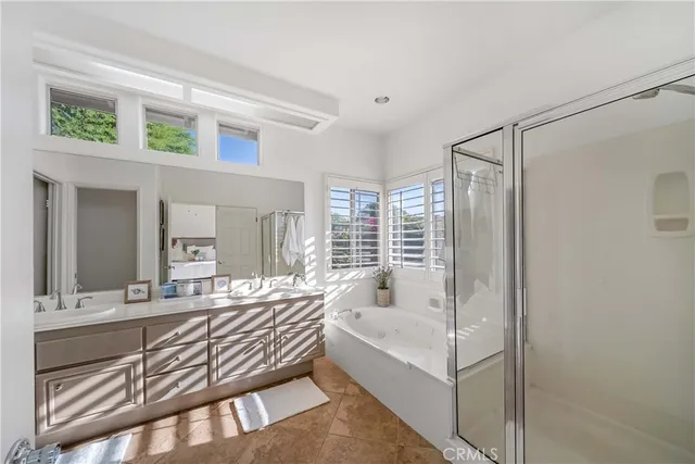 a bathroom with a tub a sink and mirrors