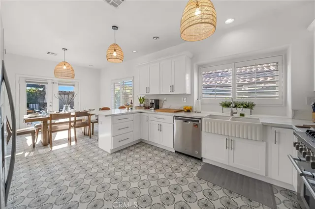 a kitchen with white cabinets and window