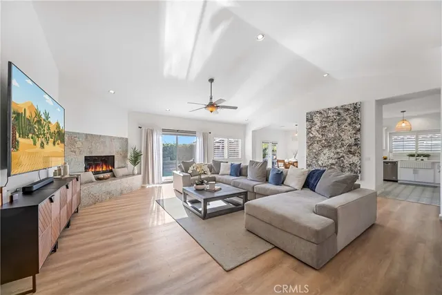 a living room with furniture a flat screen tv and a fireplace