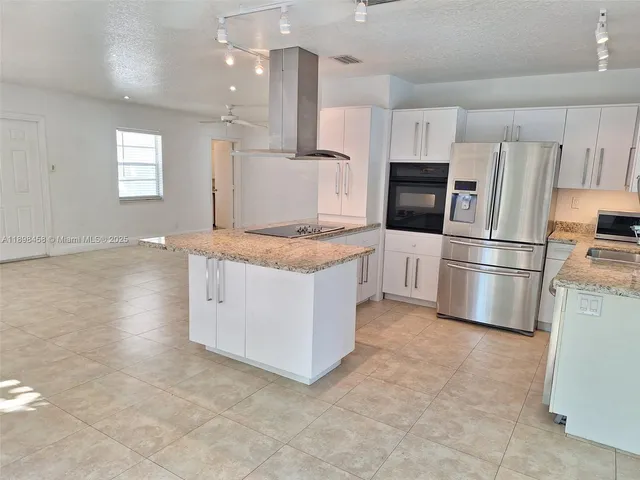 a kitchen with stainless steel appliances a refrigerator sink and microwave