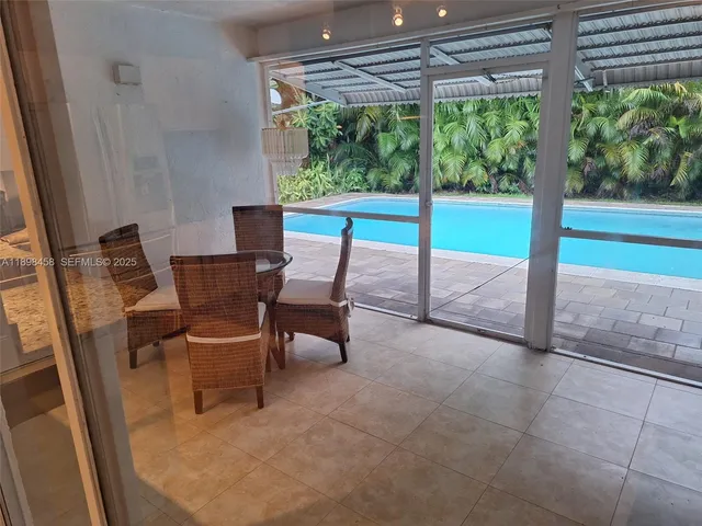 a view of a patio with table and chairs next to a window