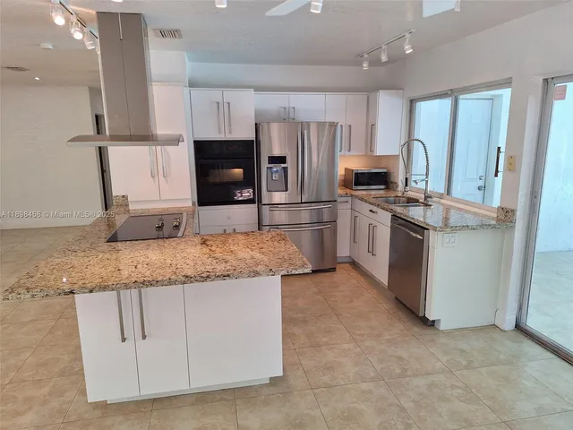 a kitchen with stainless steel appliances granite countertop a stove oven and a refrigerator