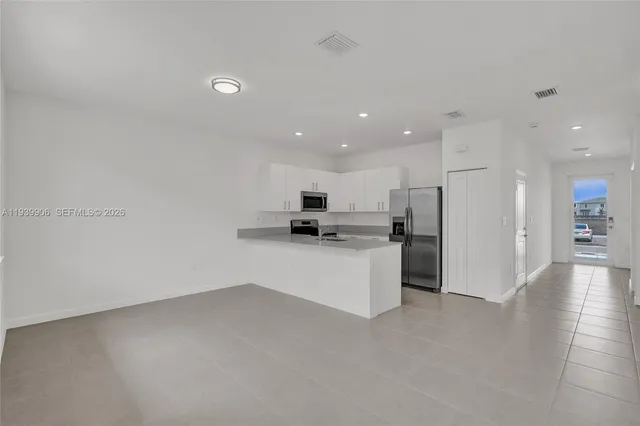 a kitchen with granite countertop white cabinets and white appliances
