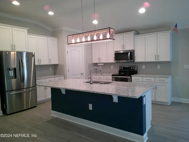 a kitchen with stainless steel appliances granite countertop a sink refrigerator and microwave