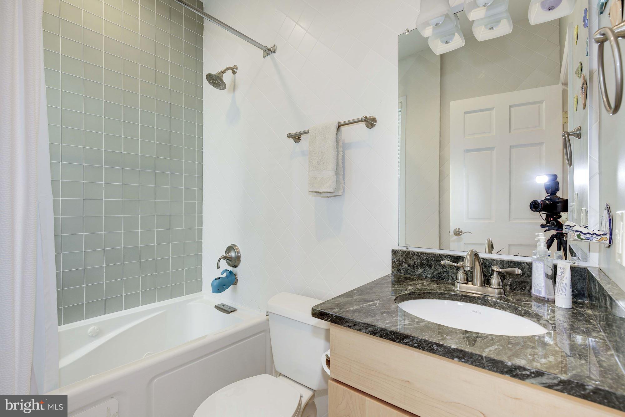231 10th Street Northeast Washington, DC 20002 - Photo 13 of 17 a bathroom with a granite countertop sink toilet and shower