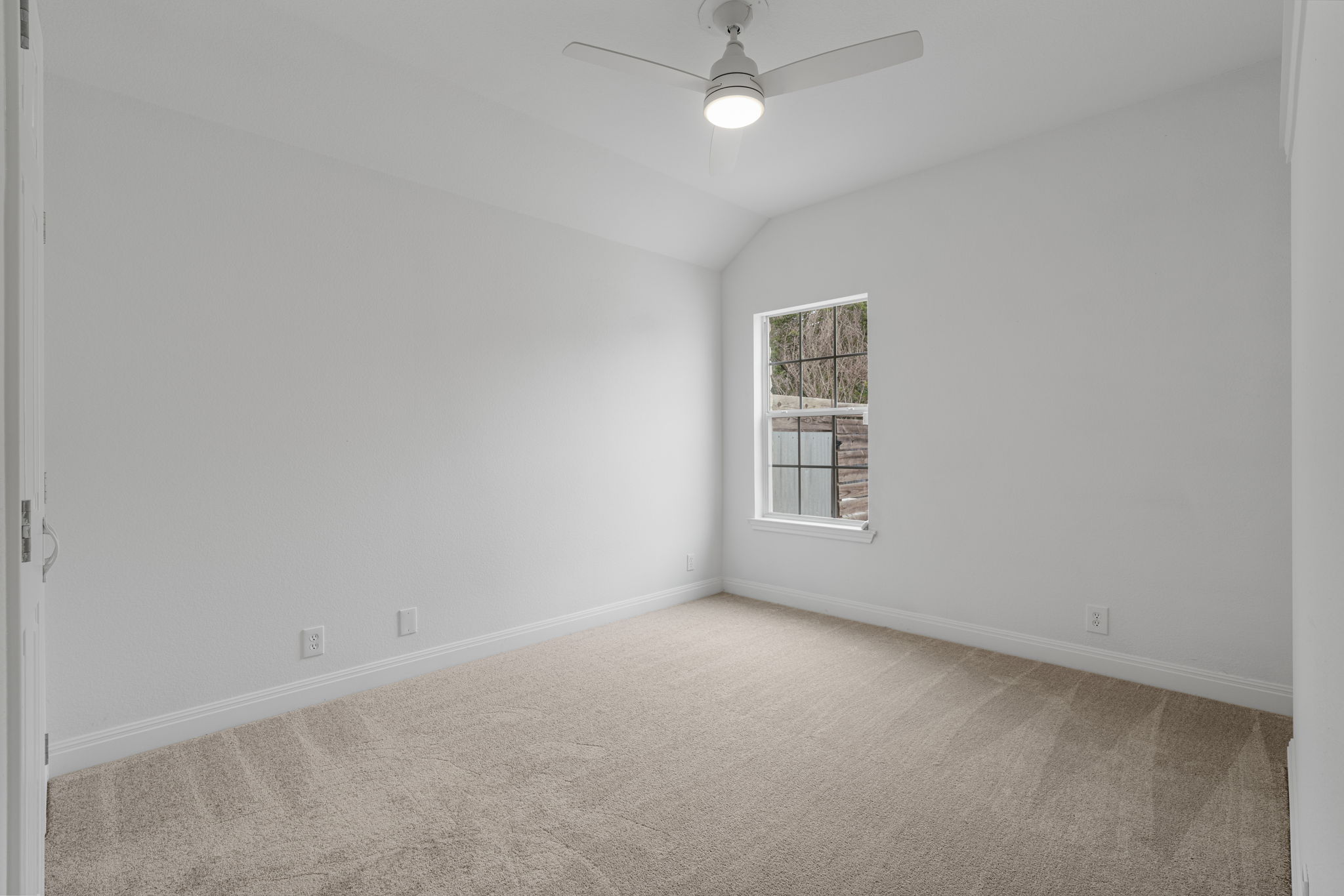 1129 Cedar Pass Road Driftwood, TX 78619 - Photo 27 of 40 Another clean, bright bedroom that features those same high vaulted ceilings you see in the rest of the house. It’s perfect as a quiet guest room or even a workout space or additional office.