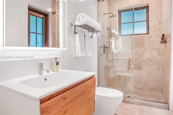 a bathroom with a sink a toilet and shower