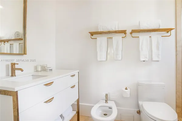 a bathroom with a sink vanity mirror and toilet