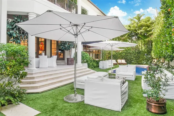a view of a chair and table in backyard of the house