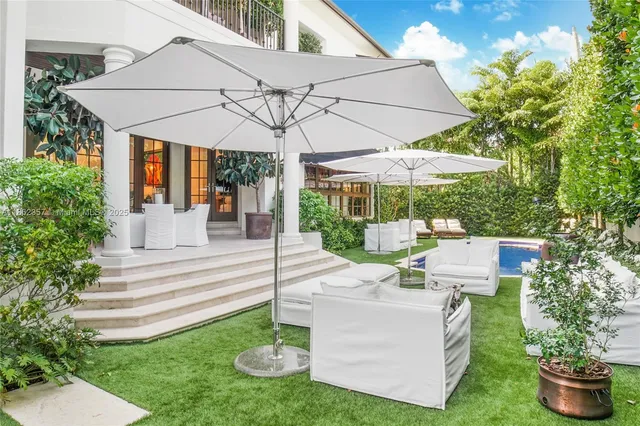 a view of a chair and table in backyard of the house