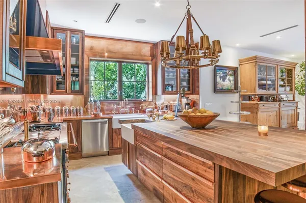 a kitchen with stainless steel appliances a sink stove and large window