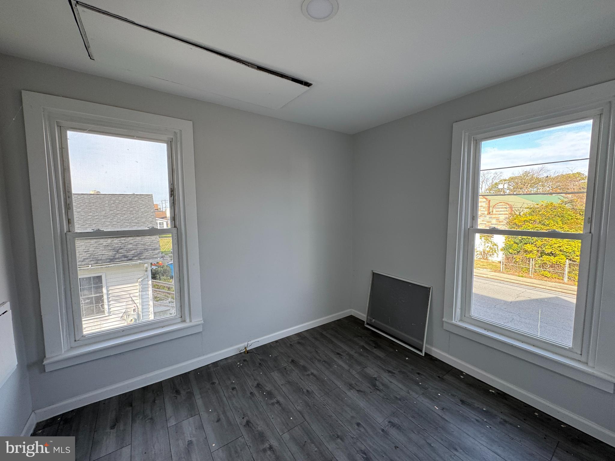313 Broadway Crisfield, MD 21817 - Photo 14 of 15 a view of an empty room with wooden floor and a window