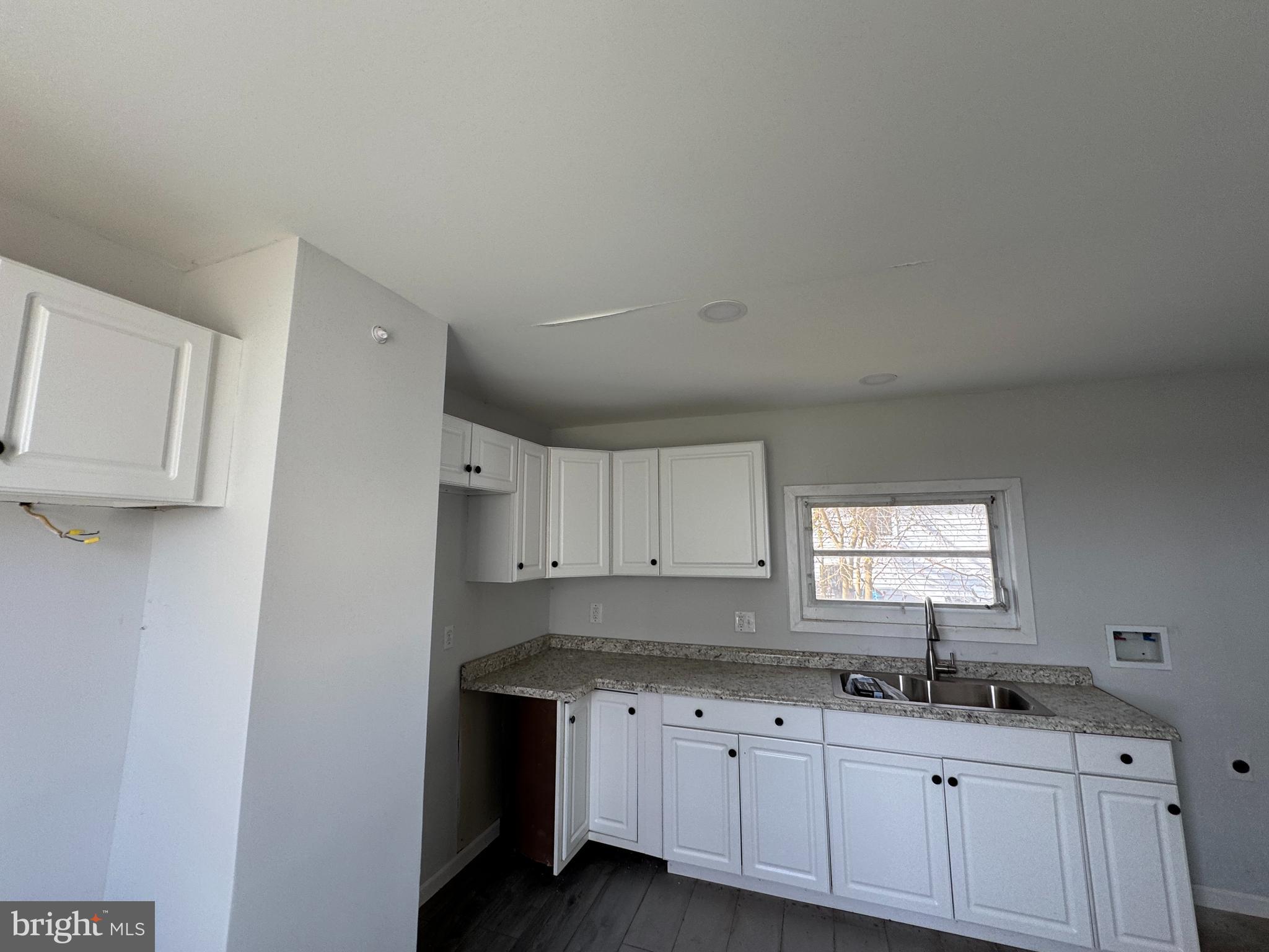 313 Broadway Crisfield, MD 21817 - Photo 5 of 15 a kitchen with granite countertop a sink a window and cabinets