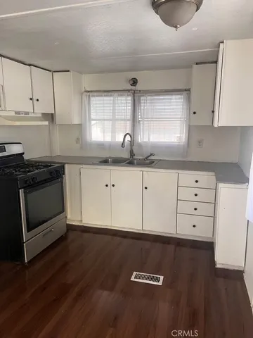 an empty room with wooden floor and windows in it