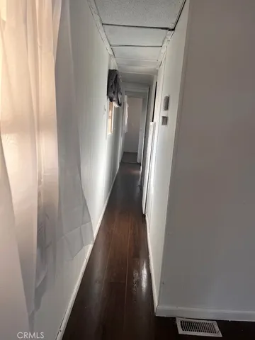 an empty room with wooden floor and windows in it