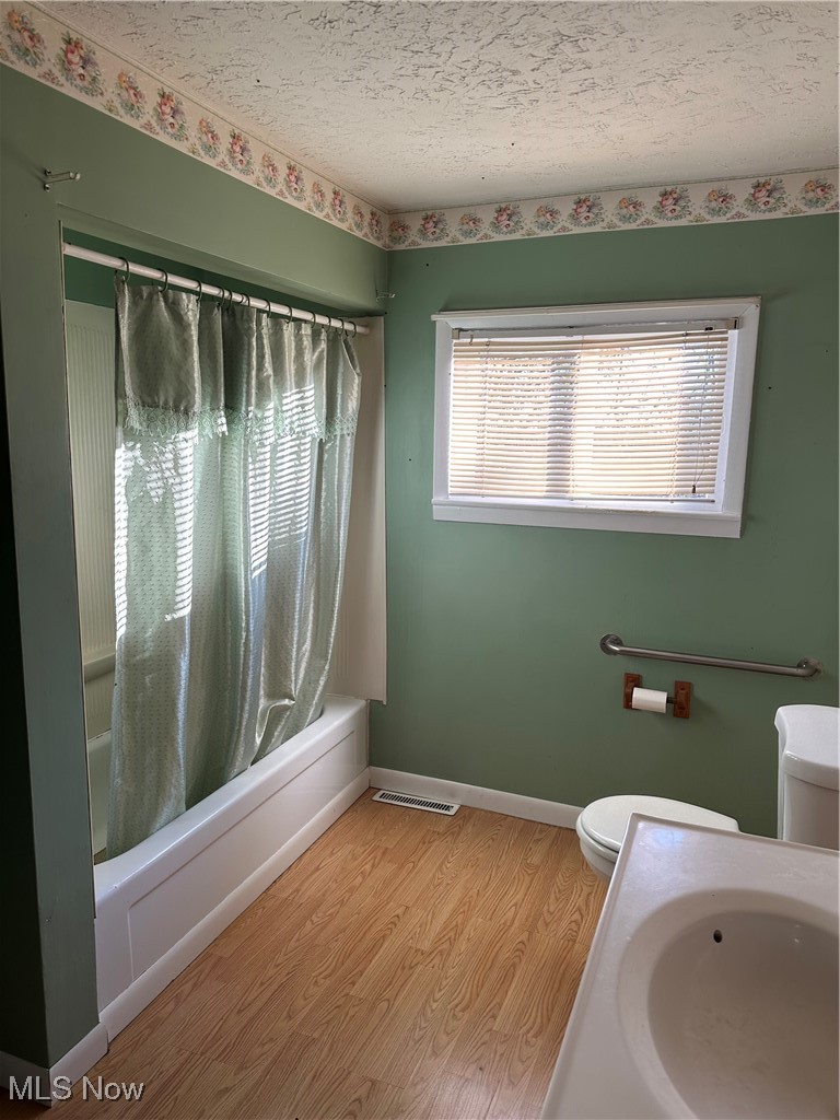 44952 Moose Ridge Road Woodsfield, OH 43793 - Photo 31 of 48 Bathroom with shower / bath combination with curtain, wood finished floors, vanity, and a textured ceiling
