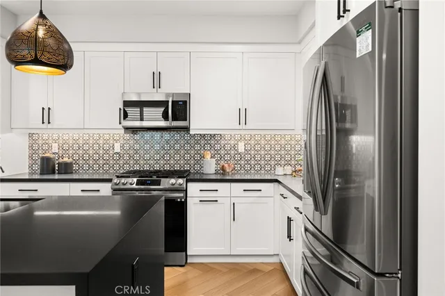 a kitchen with stainless steel appliances a stove a sink and a refrigerator