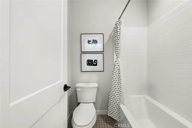 a white toilet sitting next to a bath tub