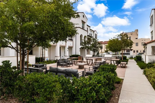 a view of a patio with couches and table and chairs and potted plants