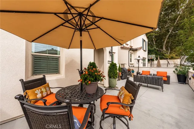 an outdoor sitting area with furniture and umbrella