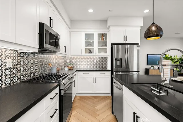 a kitchen with kitchen island granite countertop a sink a stove and refrigerator