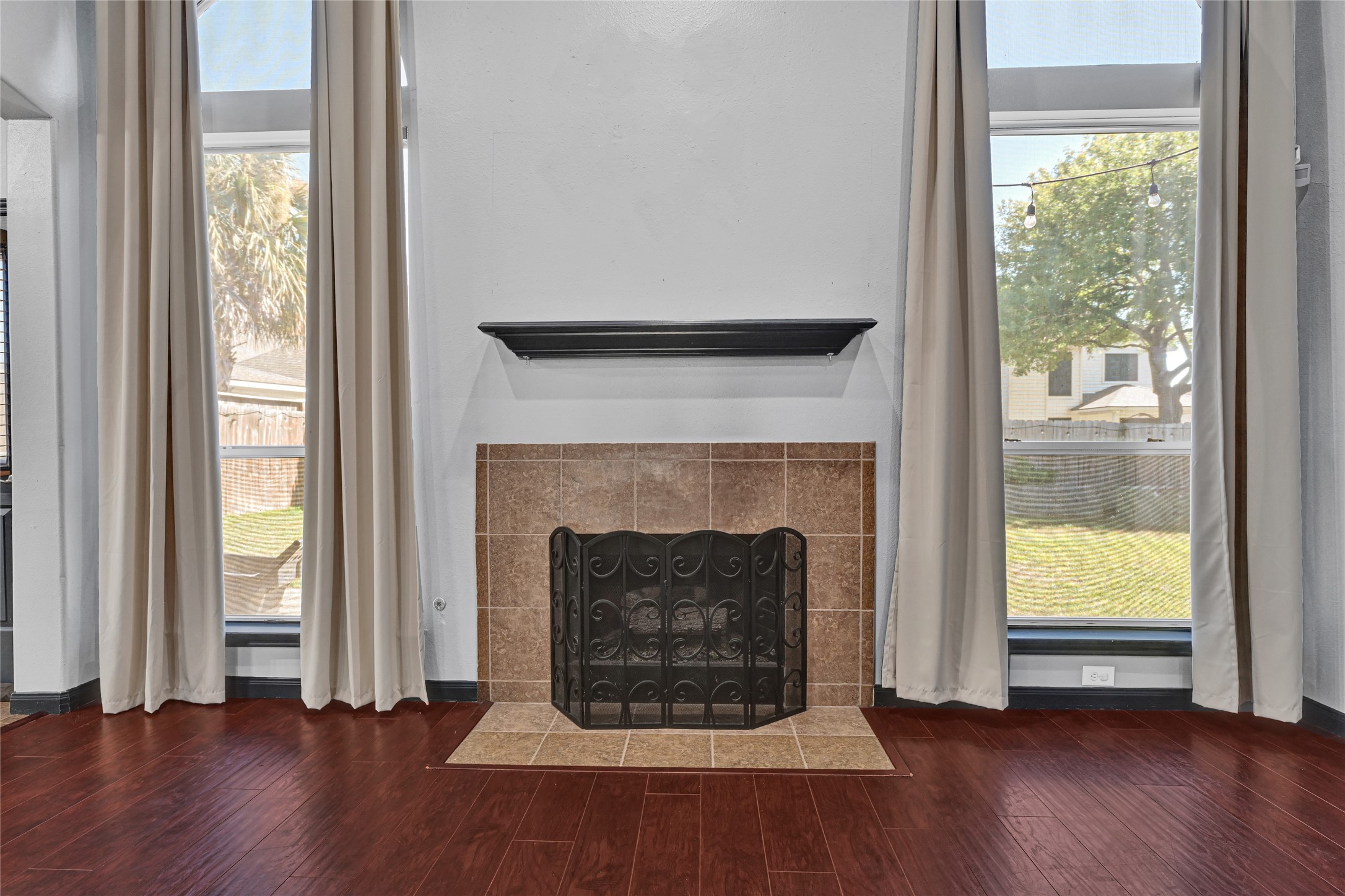 8514 Discus Drive Humble, TX 77346 - Photo 12 of 32 an empty room with wooden floor fireplace and windows