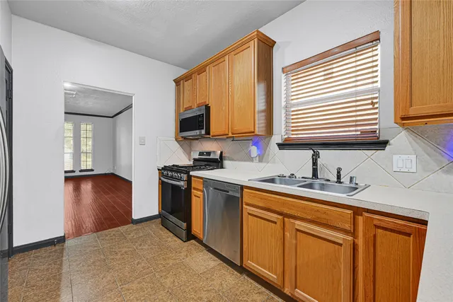 a kitchen with stainless steel appliances granite countertop a sink a stove and a refrigerator