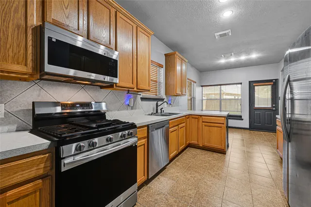 a kitchen with stainless steel appliances granite countertop a stove and a microwave