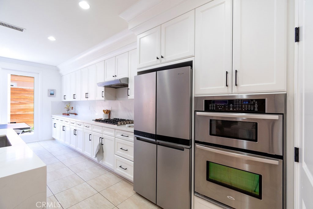 58 Cipresso Irvine, CA 92618 - Photo 11 of 34 a kitchen with granite countertop white cabinets and stainless steel appliances