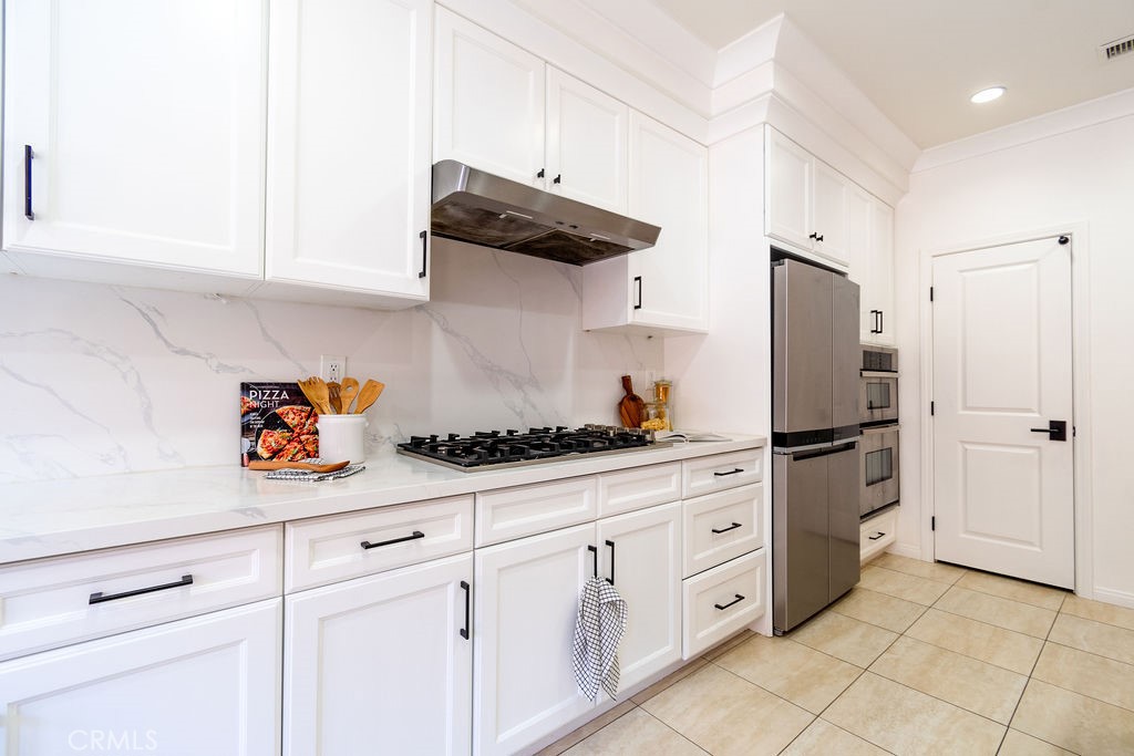 58 Cipresso Irvine, CA 92618 - Photo 12 of 34 a kitchen with white cabinets and white appliances
