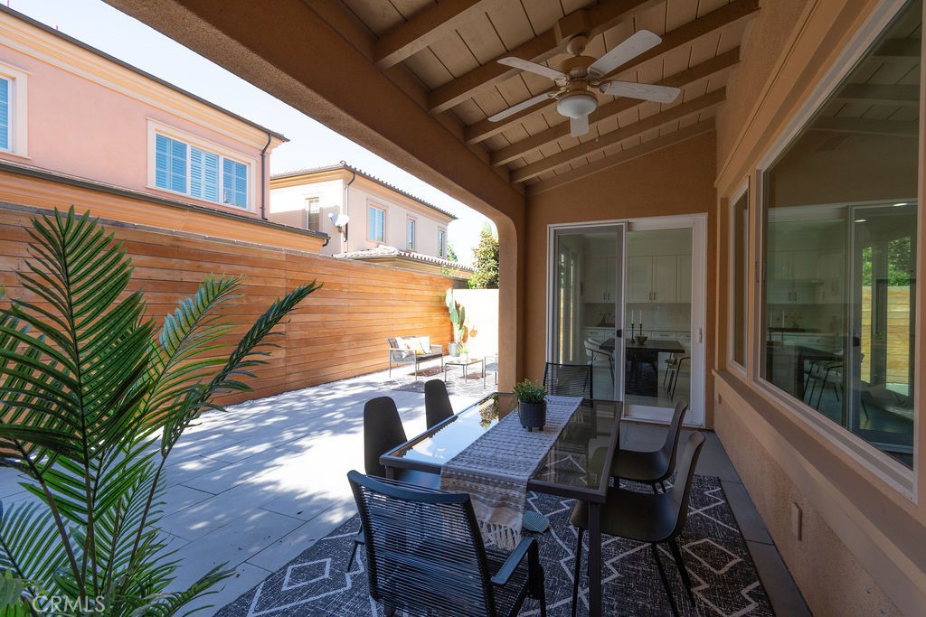 58 Cipresso Irvine, CA 92618 - Photo 23 of 34 a view of a patio with a table and chairs and floor to ceiling window with wooden floor