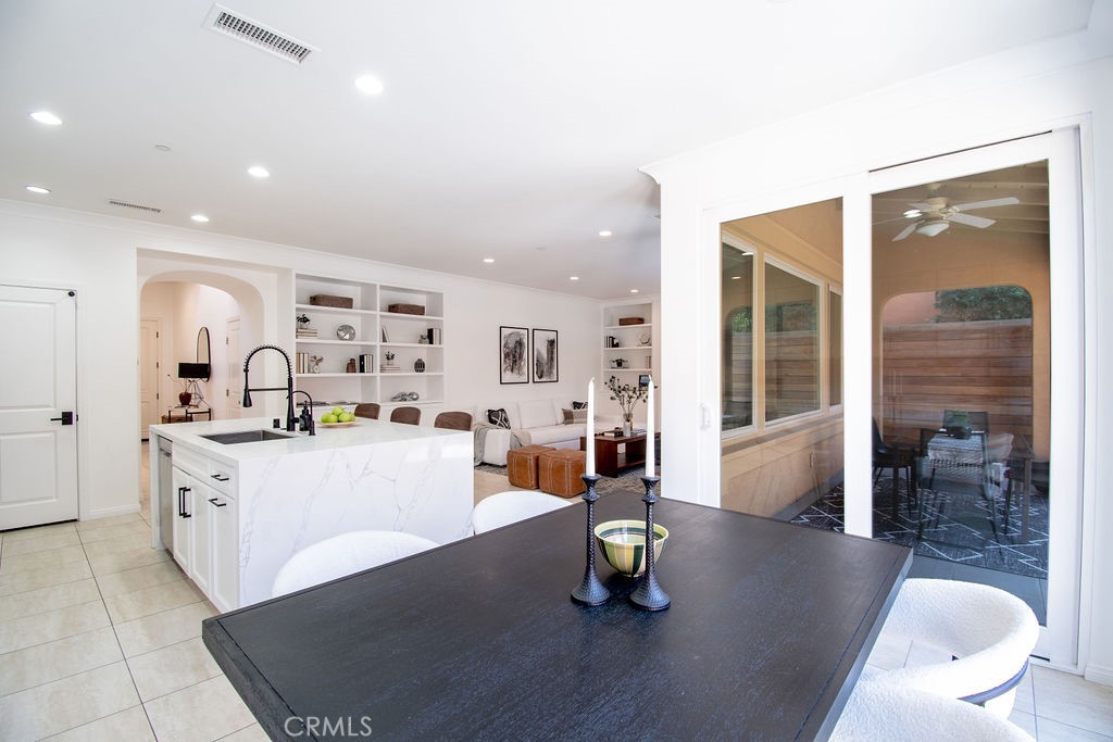 58 Cipresso Irvine, CA 92618 - Photo 9 of 34 a large white kitchen with a dining table and chairs