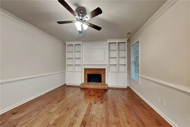wooden floor fireplace and windows in an empty room