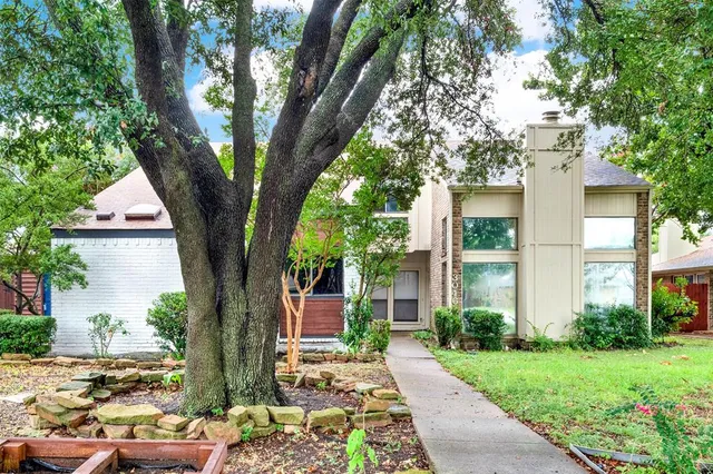 a tree in front of a white house