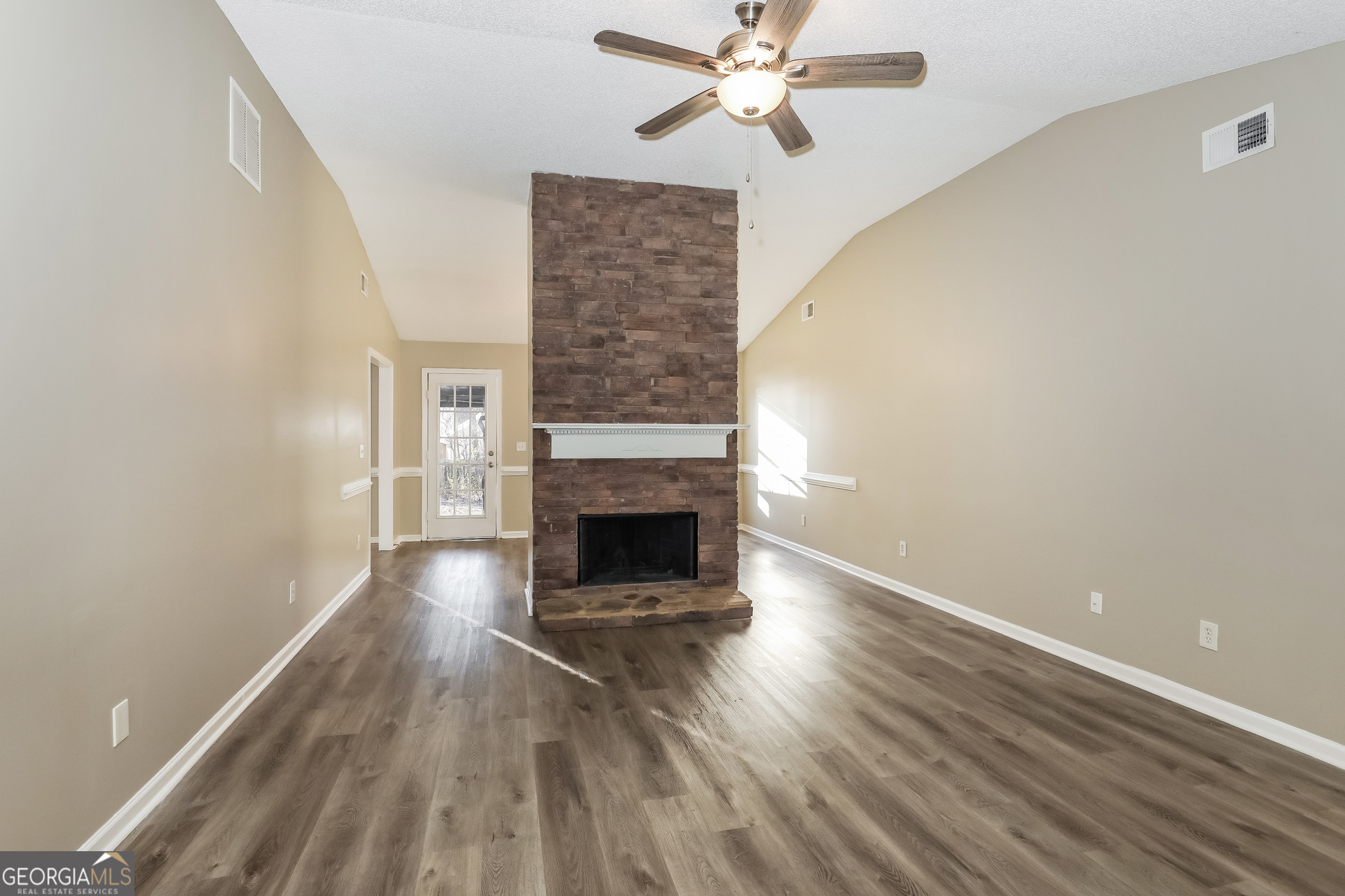 1085 Commons Court Jonesboro, GA 30238 - Photo 2 of 21 a view of an empty room with wooden floor fireplace and a window